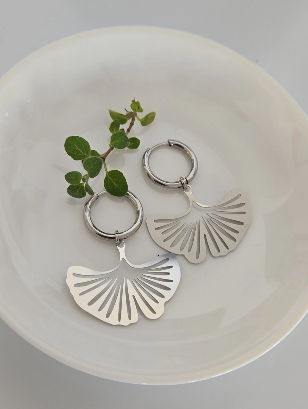 Elegant stainless steel earrings with a dangling ginkgo leaf.